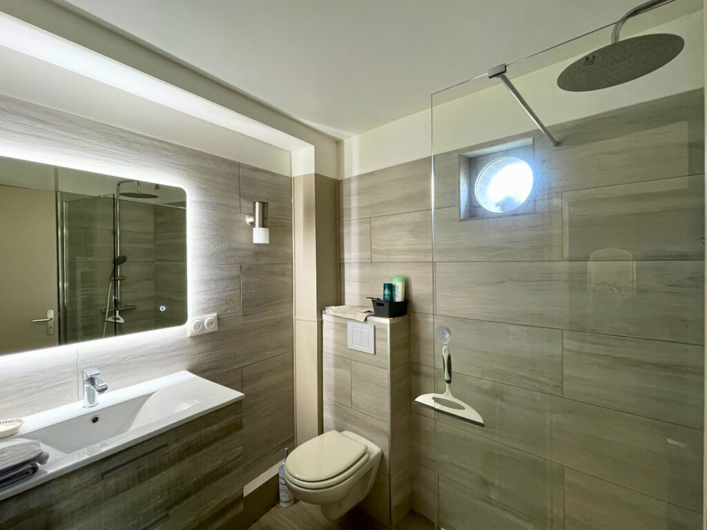 Salle de douche du studio, récemment rénovée, avec douche, vasque et WC, dans un espace optimisé et lumineux