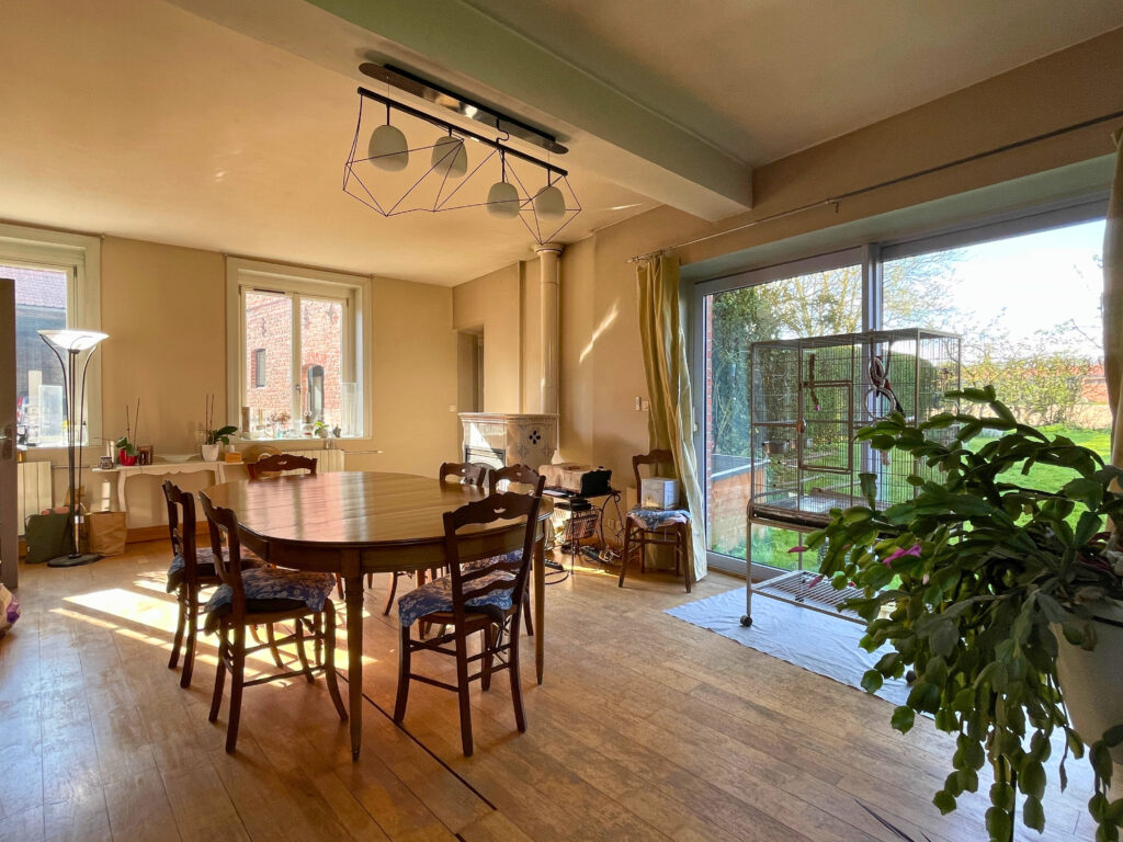 Salle à manger avec grande fenêtre, offrant une belle lumière naturelle et une vue sur l’extérieur