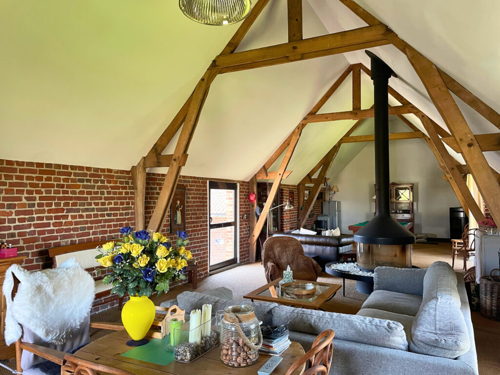 Perspective depuis l’entrée de la pièce signature, dévoilant la profondeur et le caractère du salon à l’étage