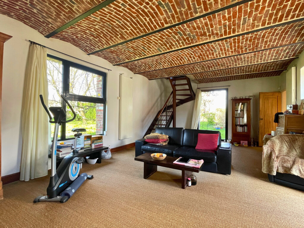 Vue traversante du salon au rez-de-chaussée, pièce séparée et chaleureuse, pouvant servir de second espace de réception