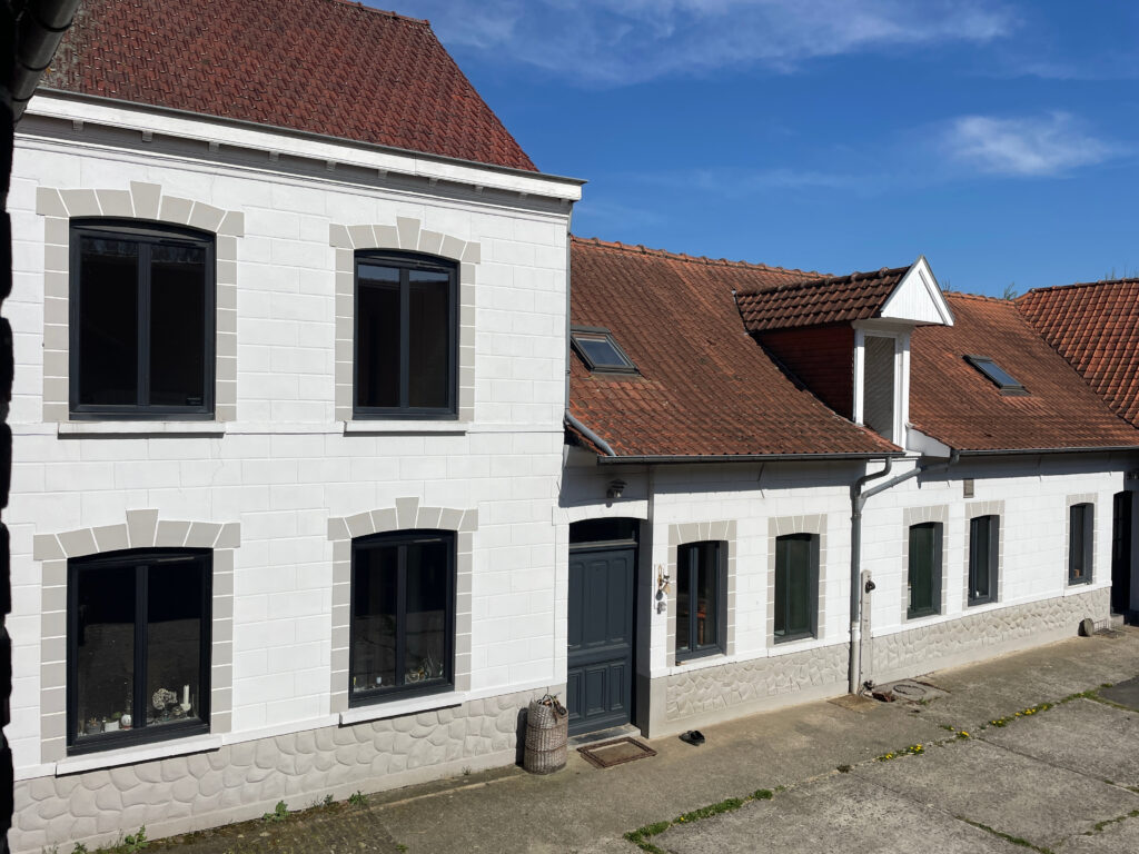 Détail de la façade blanche avec fenêtres encadrées, architecture soignée
