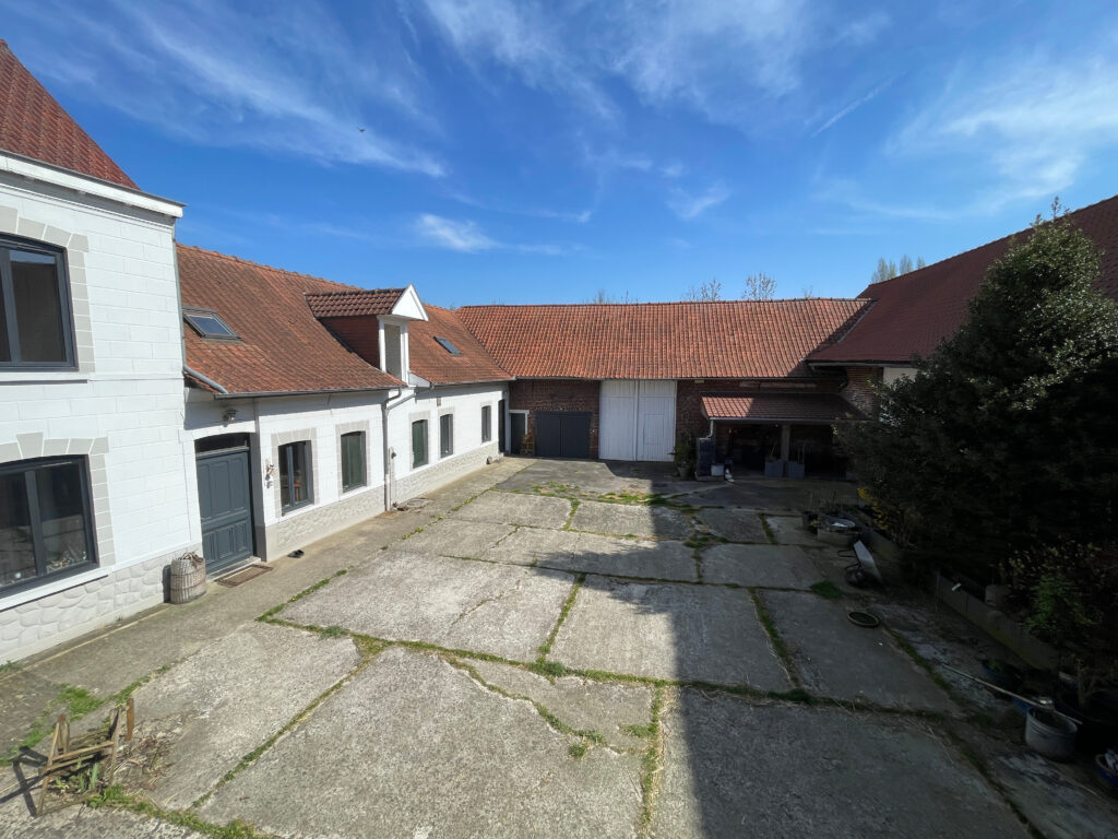 Vue globale de la cour intérieure, entièrement close, entourée par les bâtiments d’habitation et les dépendances