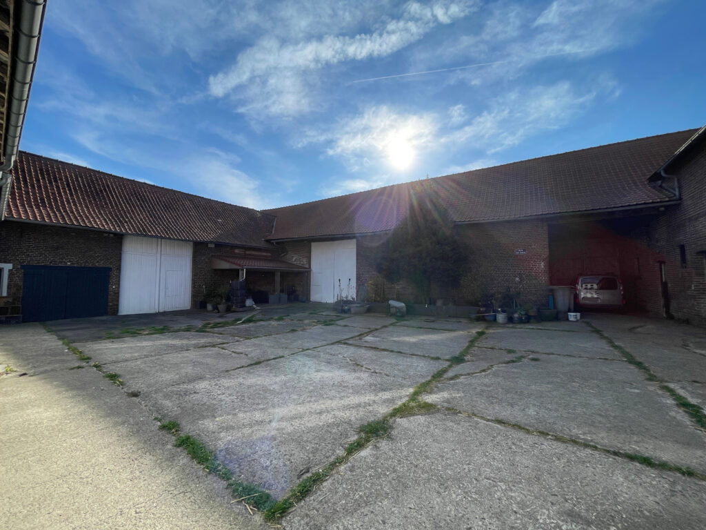 Cour intérieure de la ferme au carré avec vue sur les granges, façade en brique typique