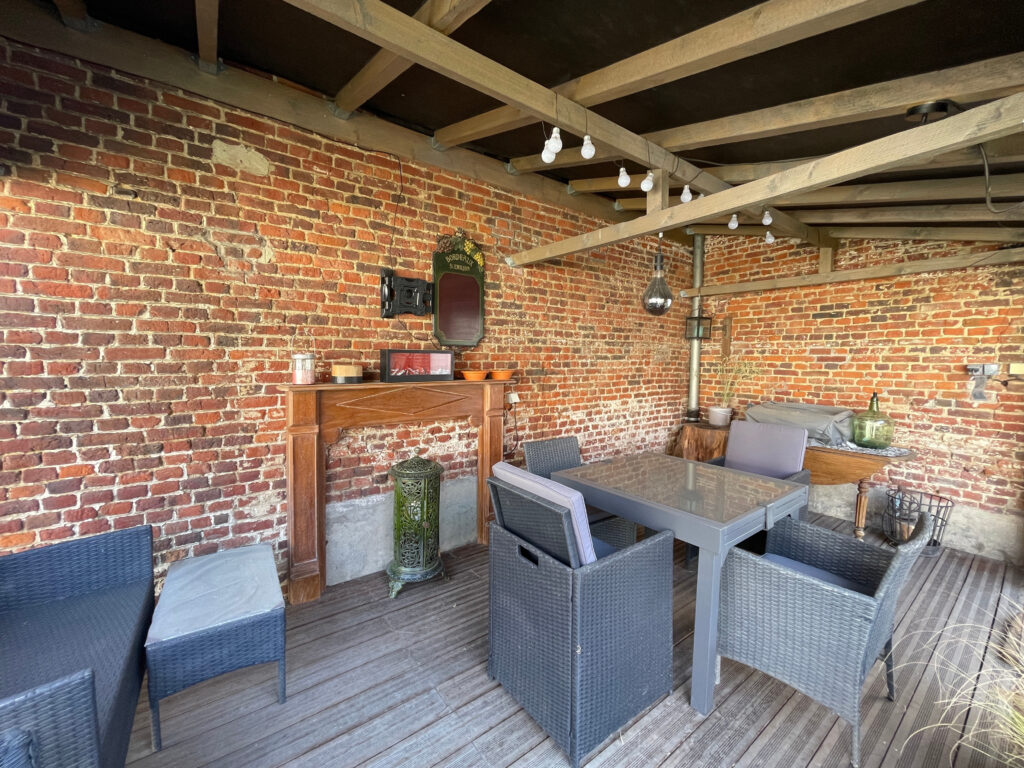 Cuisine d’été aménagée dans un espace couvert de la cour intérieure, idéale pour les repas en extérieur, à l’abri du vent et des regards