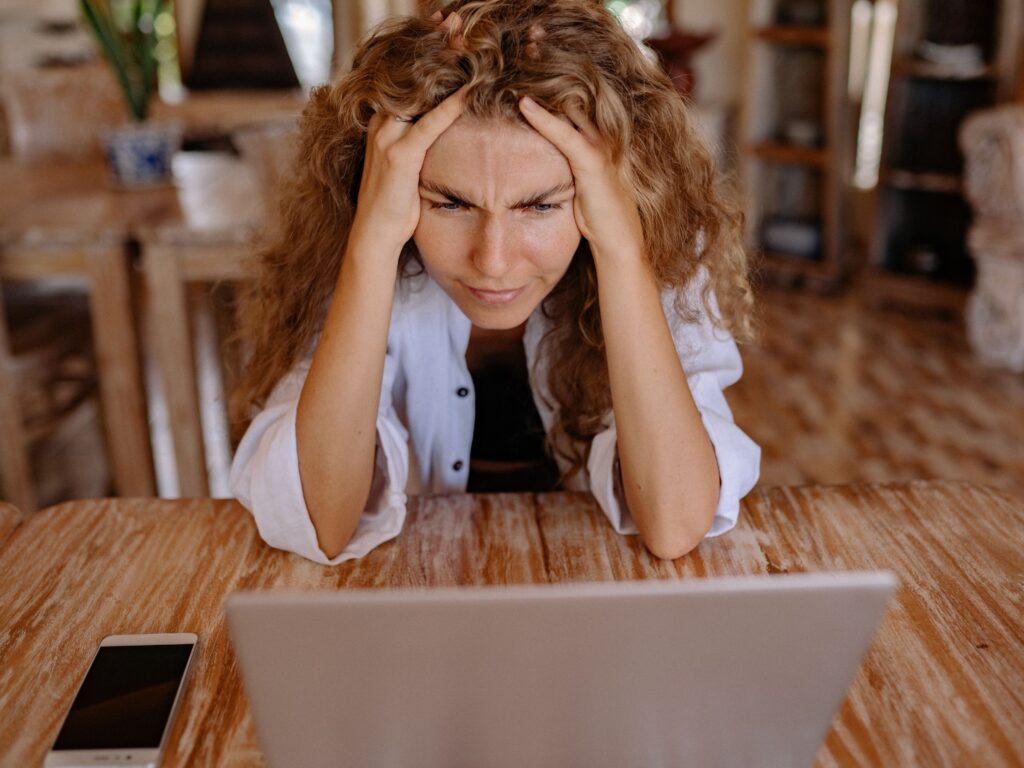 Femme contrariée devant son PC dans sa maison car sa vente n'avance pas