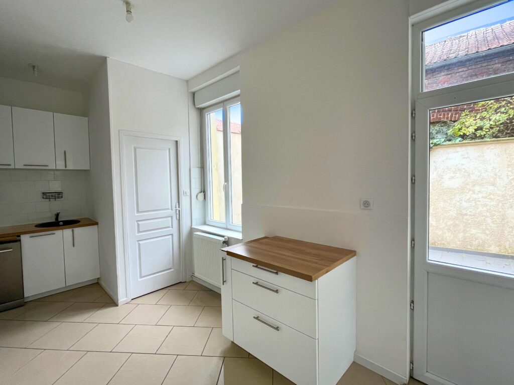 Cuisine indépendante rénovée avec meubles blancs et plan de travail bois, maison à vendre à Raimbeaucourt rue Édouard Vaillant