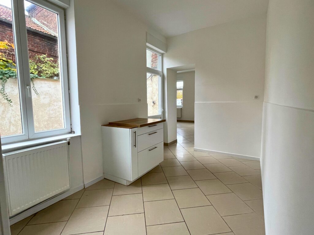 Cuisine claire avec fenêtres PVC double vitrage donnant sur le séjour, maison rénovée à vendre à Raimbeaucourt