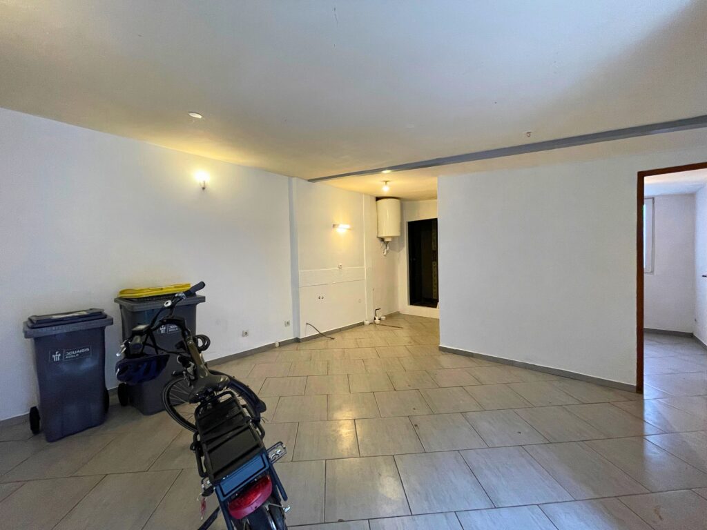 Grande pièce de vie du studio indépendant, sol carrelé et murs blancs, accès à la salle d’eau, potentiel bureau ou logement locatif à Raimbeaucourt