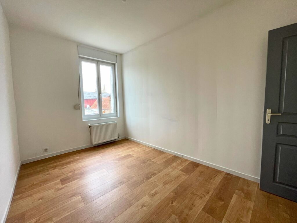 Chambre d’étage lumineuse avec sol en parquet et murs blancs, maison rénovée à vendre à Raimbeaucourt