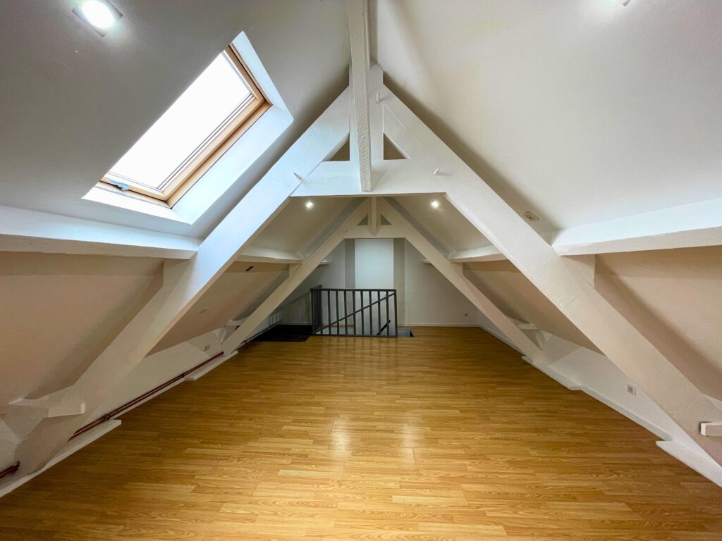 Grande chambre sous combles avec velux, poutres peintes et parquet bois, maison rénovée à Raimbeaucourt