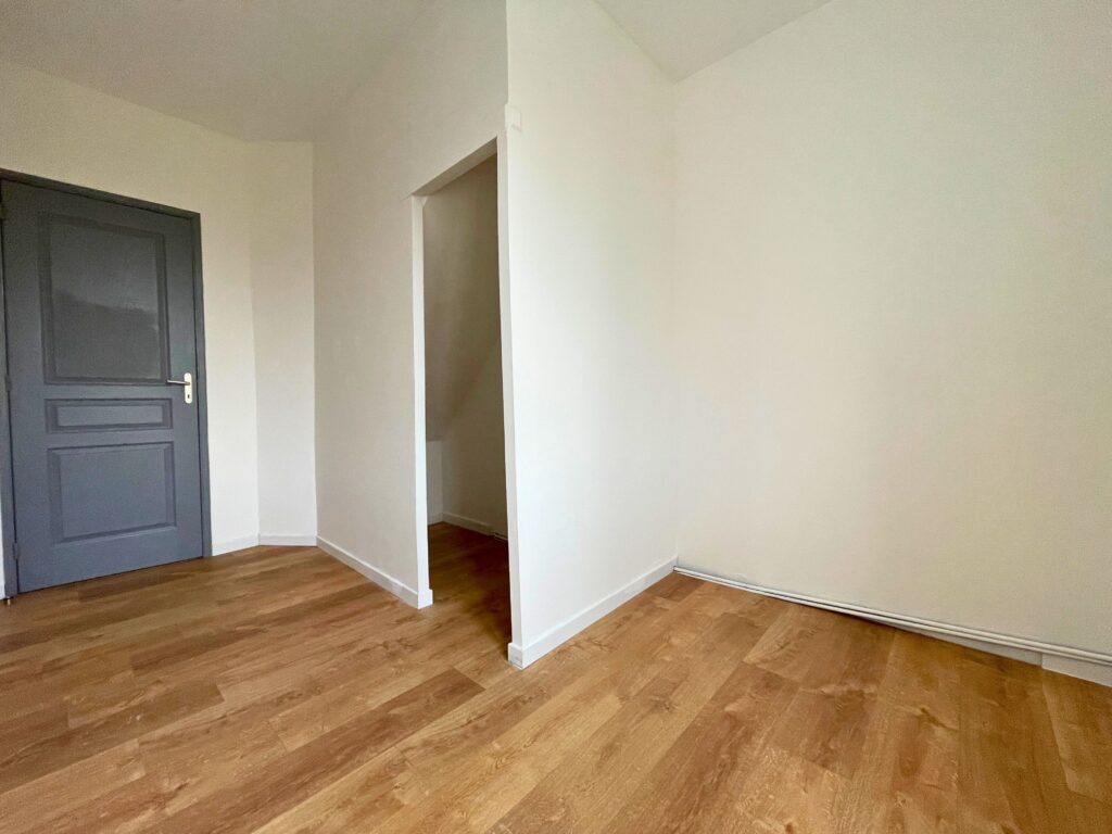 Chambre de 7,7 m² avec espace de rangement sous escalier, parquet bois clair et porte grise, maison à vendre à Raimbeaucourt