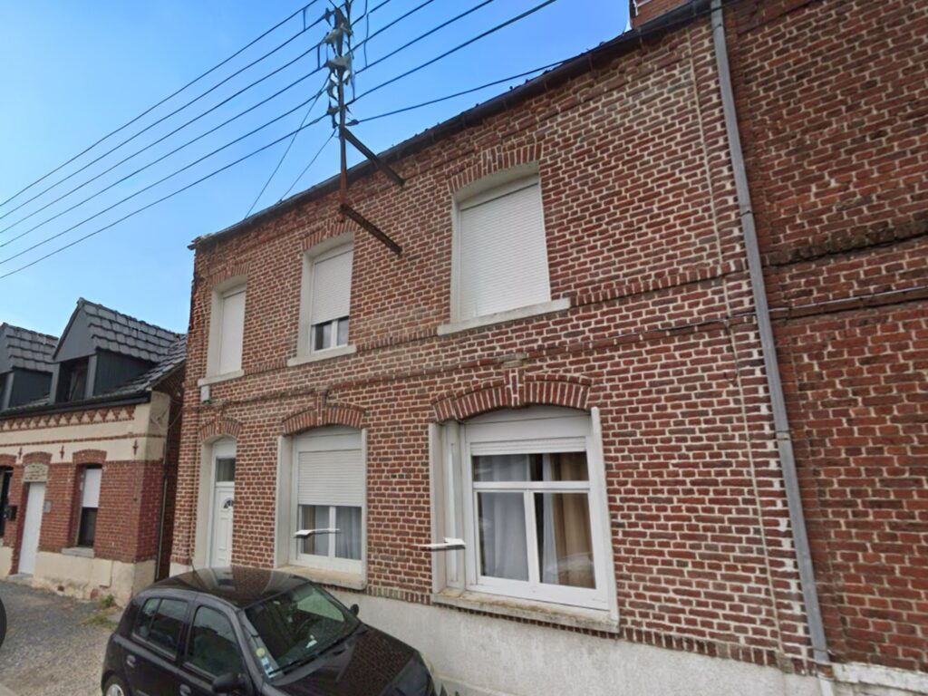 Maison rénovée en briques à Raimbeaucourt, rue Édouard Vaillant, façade typique du Nord avec fenêtres PVC et volets roulants