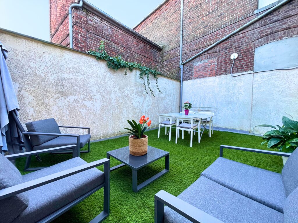 Aménagement volontairement sobre et économique, réalisable sans gros budget. Cet exemple illustre comment la cour peut devenir un véritable coin détente, sans entretien contraignant.